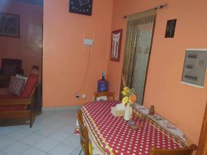 Habitación con mesa y mantel rojo y blanco en SALY KEUR EMMA, en Malikounda Sas