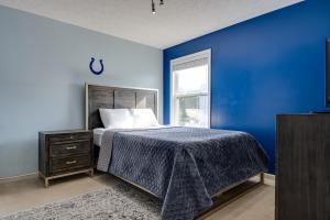 a blue bedroom with a bed and a window at Indianapolis Home with Patio and Community Pool! in Indianapolis
