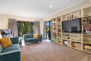 Lake TaraweraにあるRiverstone Lake Taraweraのリビングルーム(テレビ、青いソファ付)