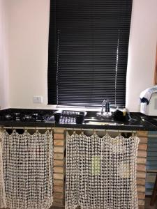 a kitchen counter with a sink and a window at Flat Maresias in Maresias