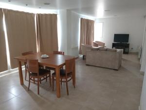 a living room with a table and chairs and a couch at Rukan in Comodoro Rivadavia