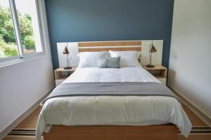 ein Schlafzimmer mit einem großen Bett und zwei Fenstern in der Unterkunft Hard Rock at Cana Pearl by Unwind Properties in Punta Cana