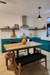 uma cozinha com uma mesa de madeira e armários azuis em Rincon Retreat,- Close to beach/ Ocean Front em Corcega
