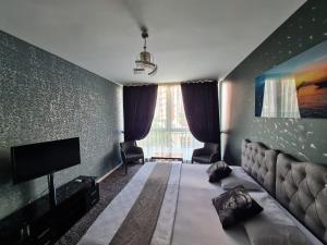 um quarto com uma cama grande e uma televisão em İNCİ HOUSE em Kırac