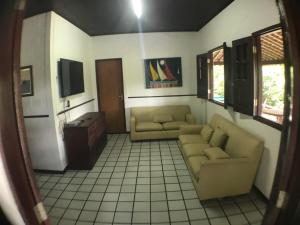 a living room with two couches and a tv at Chácara Maluco Beleza 1 in Chã Grande