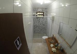 a bathroom with a shower and a sink and a toilet at Pousada Guarda Beach House in Guarda do Embaú
