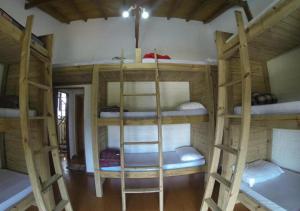 a room with four bunk beds in a house at Pousada Guarda Beach House in Guarda do Embaú