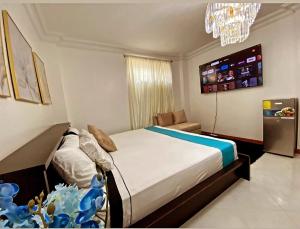 Schlafzimmer mit einem Bett und einem Kronleuchter in der Unterkunft Habitacion Master a cinco minutos del aeropuerto in Guayaquil