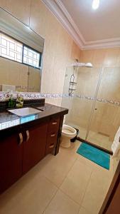 ein Bad mit einer Dusche, einem WC und einem Waschbecken in der Unterkunft Habitacion Master a cinco minutos del aeropuerto in Guayaquil