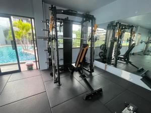 a gym with tread machines and a swimming pool at Little Loft Hotel in Phuket Town