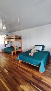 um quarto com 2 beliches e piso em madeira em Bungalows Paraíso Celeste em Bijagua