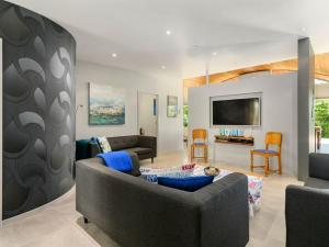 a living room with a couch and a tv at FlaxWater Lake Tarawera in Lake Tarawera