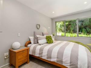 a bedroom with a large bed and a window at FlaxWater Lake Tarawera in Lake Tarawera