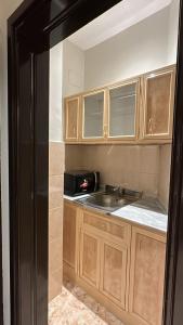a kitchen with a sink and a black refrigerator at ميلاس للوحدات المفروشة in Tabuk