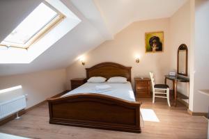 a bedroom with a bed and a desk and a window at Apart Yaroslava Osmomysla 9 Square - city center in Lviv
