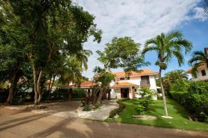 una casa con palmeras delante en Villa At Metro Country Club With Private Pool en San Pedro de Macorís