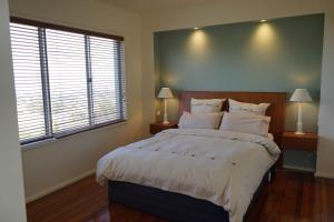 um quarto com uma cama grande e 2 janelas em Merrimont Downs em Merrijig