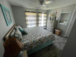 a bedroom with a bed and a dresser and a mirror at Surfside Suites in Cocoa Beach