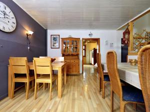 uma sala de jantar com mesa e cadeiras e um relógio em Cozy holiday home with balcony near Winterberg em Elpe