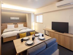 a hotel room with a bed and a table and a tv at MIMARU TOKYO UENO EAST in Tokyo