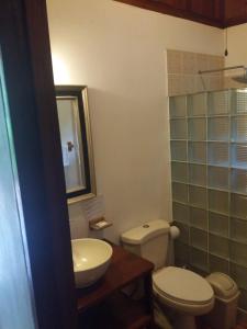 uma casa de banho com um WC e um lavatório em Los Delfines Lodge em Puerto Viejo