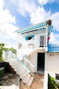 a white house with a staircase leading up to it at Studio Soleil Couchant in Pointe-Noire