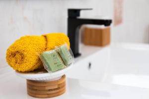 a bathroom with a yellow towel and a sink at Studio Soleil Couchant in Pointe-Noire