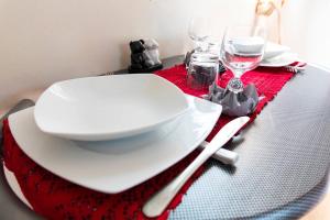 stół z białymi talerzami i kieliszkami do wina w obiekcie Studio Soleil Couchant w mieście Pointe-Noire