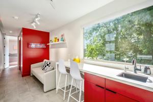 a kitchen with red and white cabinets and a large window at Strawberry Container @ EADO Juice Box in Houston