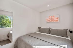 a white bedroom with a bed and a window at Strawberry Container @ EADO Juice Box in Houston +6 photos