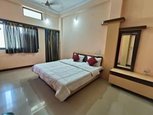a bedroom with a large bed and a mirror at Hotel chaitanya in Maheshwar
