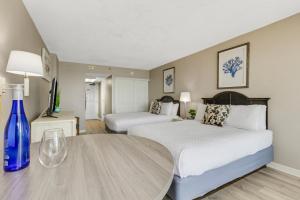 a hotel room with two beds and a table at Oceanview Studio Escape With Beach Steps Away! 1828 in Myrtle Beach +26 photos