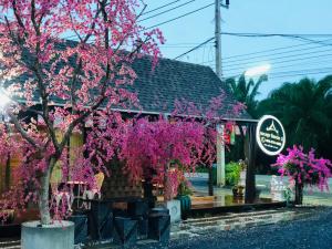 un árbol con flores rosas delante de un edificio en กอบสุข รีสอร์ท2 k13 en Ban Ton Liang