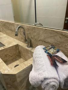 a bathroom with a sink with a towel and a mirror at Origem in Mamanguape