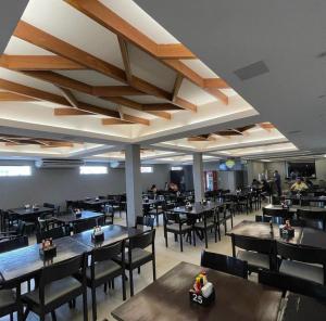 a dining room with tables and chairs and people at Origem in Mamanguape
