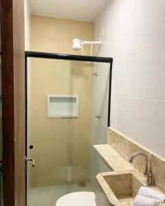 a bathroom with a glass shower with a toilet at Origem in Mamanguape