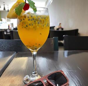 a drink in a glass sitting on a table with sunglasses at Origem in Mamanguape