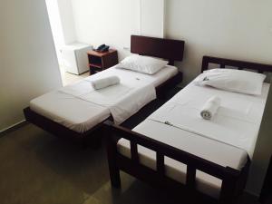 two twin beds in a room with a mirror at Hotel Preferencial Class in Bucaramanga