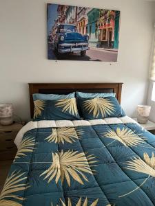 a bedroom with a bed with a blue comforter and a car at Departamento Valdivia in Los Ángeles