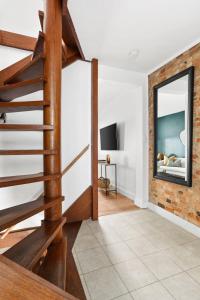 a living room with a staircase and a mirror at Stylish Darlinghurst Townhouse l 3 Bedrooms in Sydney