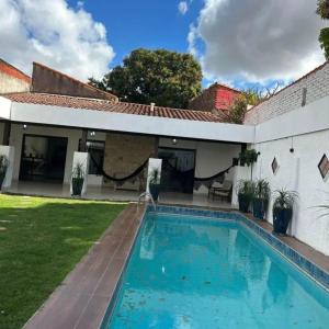 サンタ・クルス・デ・ラ・シエラにあるGuajira Hostel SCZの庭にスイミングプールがある家