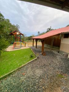 ein Spielplatz neben einem Gebäude mit einer Spielanlage in der Unterkunft Sítio Feltz in Canelinha