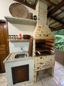 a kitchen with a brick oven with a sink at Sítio Feltz in Canelinha