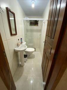 ein Badezimmer mit Waschbecken, Toilette und Spiegel in der Unterkunft Sítio Feltz in Canelinha + 21 Fotos