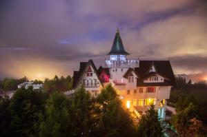 un gran edificio con una torre encima por la noche en Arts Castle en Renai