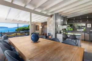 a kitchen and living room with a wooden table and chairs at Tironui Lake Tarawera in Lake Tarawera