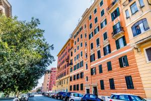 um edifício laranja alto com carros estacionados em frente em Petite Maison 19 em Roma