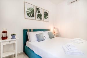 um quarto com uma cama branca com almofadas azuis e brancas em Petite Maison 19 em Roma