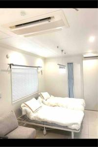 une chambre à l'hôpital avec un lit et une fenêtre dans l'établissement small villa tokyo 渋谷まで2駅10分 青山一丁目駅徒歩3分一軒家ペット歓迎お子様歓迎駐車場あり6人までOK, à Tokyo