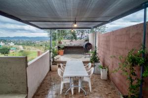 a patio with a table and chairs on a balcony at Sierras Apartamentos in Villa Santa Cruz del Lago